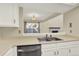 Kitchen featuring stainless steel appliances and white cabinets overlooks the bright and airy living room at 7707 S Monaco Cir, Centennial, CO 80112