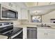 Kitchen with stainless steel appliances and white cabinetry, overlooking a spacious living room at 7707 S Monaco Cir, Centennial, CO 80112