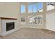 Spacious living room boasts large windows, a fireplace, carpeted floors, and a neutral color palette at 7707 S Monaco Cir, Centennial, CO 80112