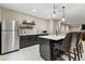 Basement bar with stainless steel refrigerator, stylish cabinets, and marble countertop island with seating at 428 Pontiac St, Denver, CO 80220