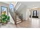 Grand foyer featuring a staircase with iron railing, hardwood floors, and elegant lighting at 428 Pontiac St, Denver, CO 80220