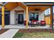 Relaxing front porch has comfortable seating, wood ceiling, ceiling fan, and stone pillars at 428 Pontiac St, Denver, CO 80220