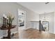 Bright hallway featuring hardwood floors, an elegant chandelier, and a peek into the adjacent bedroom at 428 Pontiac St, Denver, CO 80220