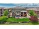 Exterior rear of home showing a backyard featuring a fire pit, lush grass, and mature trees at 27625 E Moraine Dr, Aurora, CO 80016