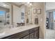 Bathroom featuring dual sinks, modern fixtures, and framed artwork, with a doorway view of a bedroom at 27625 E Moraine Dr, Aurora, CO 80016