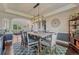 Stylish dining room with modern chandelier, farmhouse table, and view into the living area at 27625 E Moraine Dr, Aurora, CO 80016