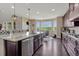 Spacious kitchen featuring dark cabinets, granite countertops, stainless steel appliances, and eat in dining area with golf course view at 27625 E Moraine Dr, Aurora, CO 80016