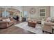 Spacious living room featuring dark wood floors, a large sectional sofa, and abundant natural light at 27625 E Moraine Dr, Aurora, CO 80016