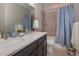 Bathroom exhibiting double sinks with modern fixtures, a tub-shower combination, and stylish decor at 10177 E 62Nd Ave, Denver, CO 80238