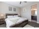 Bedroom features a rustic wood bed frame, neutral colors, and a glimpse of an ensuite bathroom at 10177 E 62Nd Ave, Denver, CO 80238