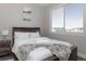 A serene bedroom provides a window view and is furnished with a comfortable wood-trimmed bed at 10177 E 62Nd Ave, Denver, CO 80238