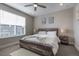 Bright bedroom with a rustic wood bed frame, a ceiling fan, and neutral colors to create a relaxing atmosphere at 10177 E 62Nd Ave, Denver, CO 80238