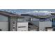 Contemporary townhomes showcase gray roofs against a backdrop of majestic mountains and Denver's skyline at 10177 E 62Nd Ave, Denver, CO 80238
