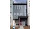 A modern multi-story townhouse features a covered porch with outdoor seating and a bold red front door at 10177 E 62Nd Ave, Denver, CO 80238