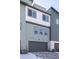 Modern townhome features a spacious gray garage, complemented by contemporary exterior paint colors at 10177 E 62Nd Ave, Denver, CO 80238