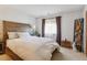 Comfortable bedroom with a wooden headboard, window with sheer curtains, and complementary decorative elements at 9942 Lane St, Thornton, CO 80260