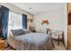 A calm bedroom features a soft quilt, window with sheer curtains, and a cozy chair for reading or relaxation at 9942 Lane St, Thornton, CO 80260