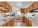 Bright kitchen featuring light wood cabinetry, white countertops, and views to the living area and breakfast nook at 9942 Lane St, Thornton, CO 80260