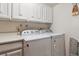 Convenient laundry room features a side-by-side washer and dryer and additional storage space above at 9942 Lane St, Thornton, CO 80260
