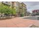 Exterior view of apartment building with small balconies, sidewalk, trees and a parking lot in the background at 5677 S Park Pl # D310, Greenwood Village, CO 80111