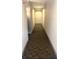Long hallway with neutral-colored carpet and white walls leading to an unknown destination at 5677 S Park Pl # D310, Greenwood Village, CO 80111