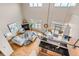 A bright living room is displayed from an aerial view, including a fireplace, kitchen, and walk-out balcony at 5677 S Park Pl # D310, Greenwood Village, CO 80111