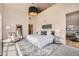 Spacious bedroom featuring a large bed, plush rug, tall ceilings, and an open view to other spaces at 5677 S Park Pl # D310, Greenwood Village, CO 80111