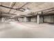 Large, well-lit parking garage with visible piping on the ceiling; shows potential car parking spaces at 5677 S Park Pl # D310, Greenwood Village, CO 80111