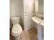 A half bathroom featuring a pedestal sink, toilet, and tile floor at 1703 S Moline Ct, Aurora, CO 80012