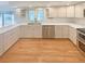 Modern kitchen with white cabinetry, stainless steel appliances, and hardwood flooring at 1703 S Moline Ct, Aurora, CO 80012