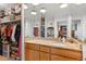 Bathroom vanity with granite counters and multiple mirrors reflects the ample storage in the walk-in closet at 4570 E Yale Ave # 1104, Denver, CO 80222