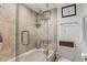 Elegant bathroom features a glass-enclosed tub with tiled surround, toilet, and coordinating fixtures at 4570 E Yale Ave # 1104, Denver, CO 80222