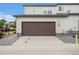Attached two-car garage featuring a paved driveway and modern exterior finishes on the home at 4760 Kittredge St, Denver, CO 80239