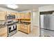 Kitchen with stainless steel appliances, tile backsplash, and ample cabinet space at 710 S Alton Way # 5A, Denver, CO 80247