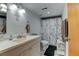 Well-lit bathroom with double vanity and shower/tub combo, offering a clean and functional space at 1256 Ulster St, Denver, CO 80220