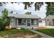Cute single-story home with an enclosed porch and a lovely garden detail at 1256 Ulster St, Denver, CO 80220