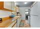 Functional kitchen with white appliances, wood countertops, and tile flooring, conveniently laid out for meal preparation at 1256 Ulster St, Denver, CO 80220