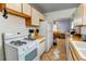 Well-equipped kitchen featuring tile floors, white appliances, and access to the adjacent dining area at 1256 Ulster St, Denver, CO 80220