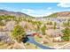 Beautiful aerial view of homes surrounded by green trees and mountains in the background at 96 Greeley Blvd, Palmer Lake, CO 80133