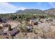 Aerial view of a cozy neighborhood nestled amongst lush trees with views of the beautiful mountains in the background at 96 Greeley Blvd, Palmer Lake, CO 80133