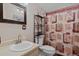 Well-lit bathroom with a sink, mirror, and a shower with decorative curtains at 96 Greeley Blvd, Palmer Lake, CO 80133
