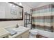 Clean bathroom featuring a mirror, sink, toilet, and shower with striped curtain at 96 Greeley Blvd, Palmer Lake, CO 80133