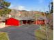 Charming single-Gathering home featuring a bright red exterior, attached garage, and a spacious driveway nestled in a scenic mountain setting at 96 Greeley Blvd, Palmer Lake, CO 80133