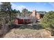 Charming single-Gathering home featuring a bright red exterior nestled amongst lush trees with mountain views at 96 Greeley Blvd, Palmer Lake, CO 80133