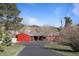 Charming single-Gathering home featuring a bright red exterior, attached garage, and a spacious driveway nestled in a scenic mountain setting at 96 Greeley Blvd, Palmer Lake, CO 80133