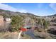 Exterior view of a red home surrounded by trees and beautiful scenery at 96 Greeley Blvd, Palmer Lake, CO 80133