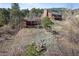 Exterior view of a residence with a small red house and a large home with a stone chimney at 96 Greeley Blvd, Palmer Lake, CO 80133