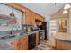 Kitchen with oak cabinets, a view to the outside, stainless appliances, and tile backsplash at 96 Greeley Blvd, Palmer Lake, CO 80133