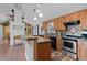 Kitchen with oak cabinetry, tile backsplash, stainless appliances, and a breakfast bar at 96 Greeley Blvd, Palmer Lake, CO 80133