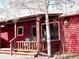 Cozy porch with wood railings, chairs, and exterior log siding at 96 Greeley Blvd, Palmer Lake, CO 80133